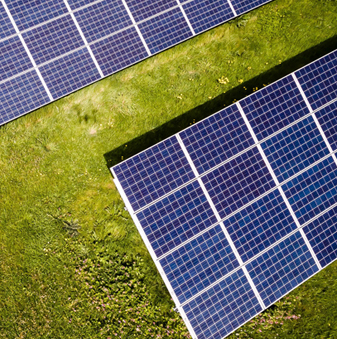 services-2a Aerial photo of solar panels resting on a grassy field.